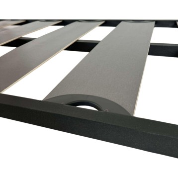 Cama con estructura negra y láminas grises y blancas alternadas con asas laterales en detalle de sistema de soporte