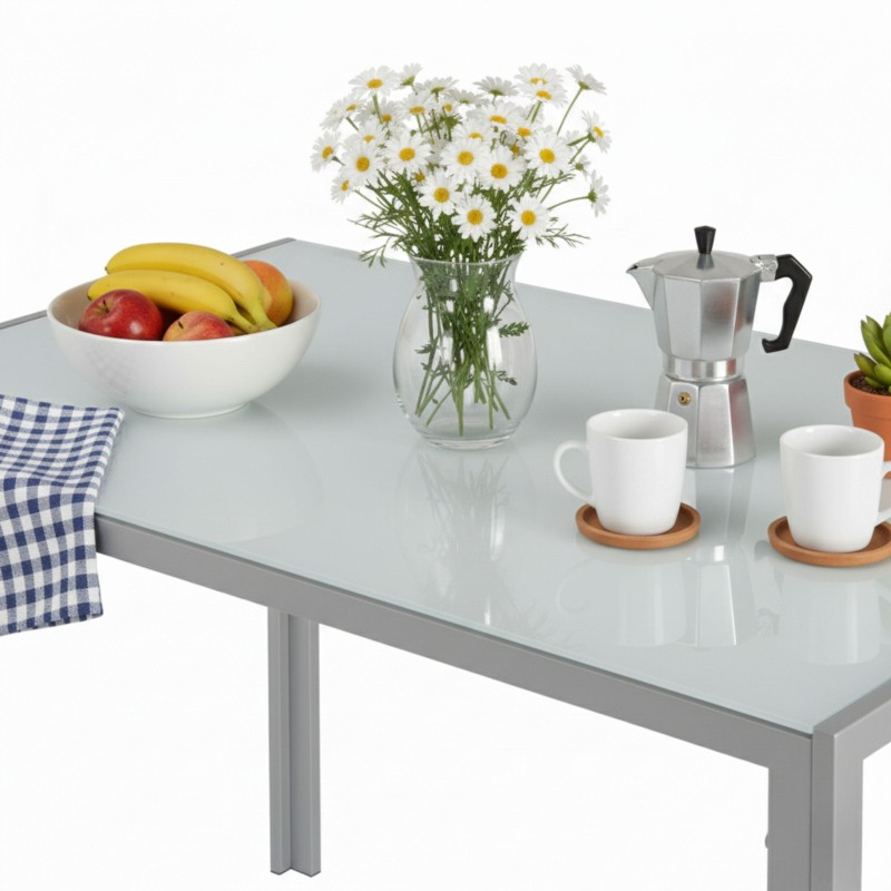 Mesa de comedor blanca con tapa de cristal y patas metálicas grises en ambiente decorado