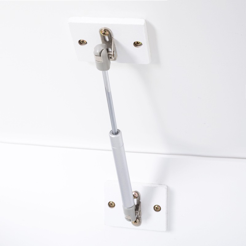 Tirador de mueble blanco con tubo metálico y soportes de fijación de latón instalado en el baúl