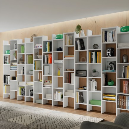 Estanterías modulares blancas y madera con compartimentos abiertos para libros y decoración en ambiente de salón