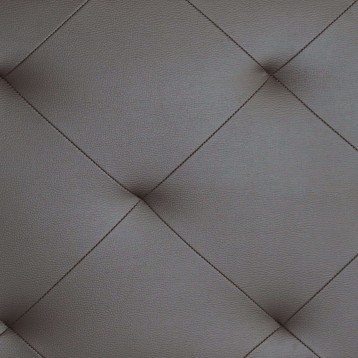 Detalle de tapizado acolchado en cuero gris con costura romboidal y textura de cuero genuino