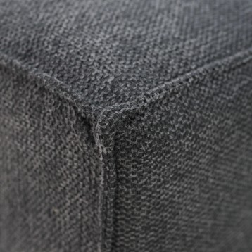 Detalle de tapizado gris oscuro con textura de tejido y costura en esquina