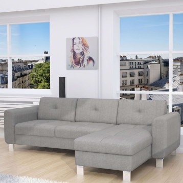Sofá seccional gris claro con chaise longue y patas metálicas en ambiente luminoso con vistas urbanas