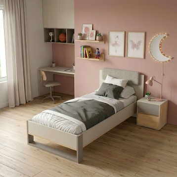 Cama infantil de madera y tapizado gris claro con cabecero textil en dormitorio rosa y escritorio integrado