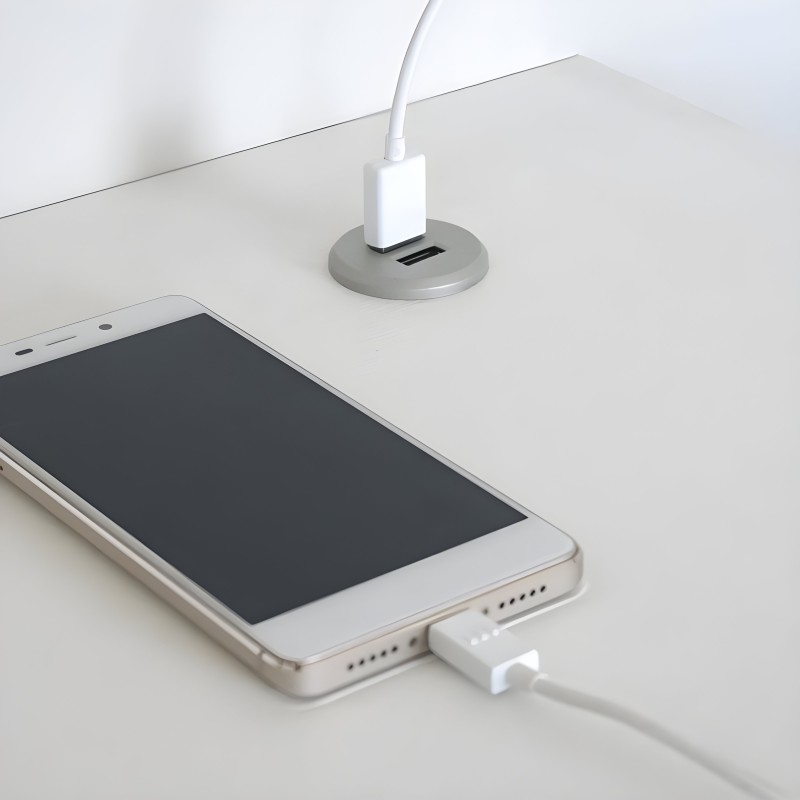 Organizador de cables de escritorio color gris con puertos USB y soporte para cargadores sobre superficie blanca
