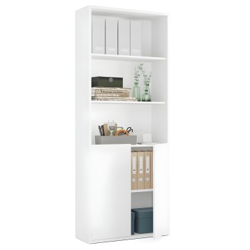 Estantería blanca modular con compartimentos abiertos y armario inferior de madera y puertas. Estilizada con libros y plantas de