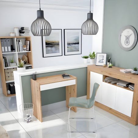 Ambiente de oficina en casa con escritorio de madera y blanco y silla verde junto a estanterías y lámparas colgantes negras