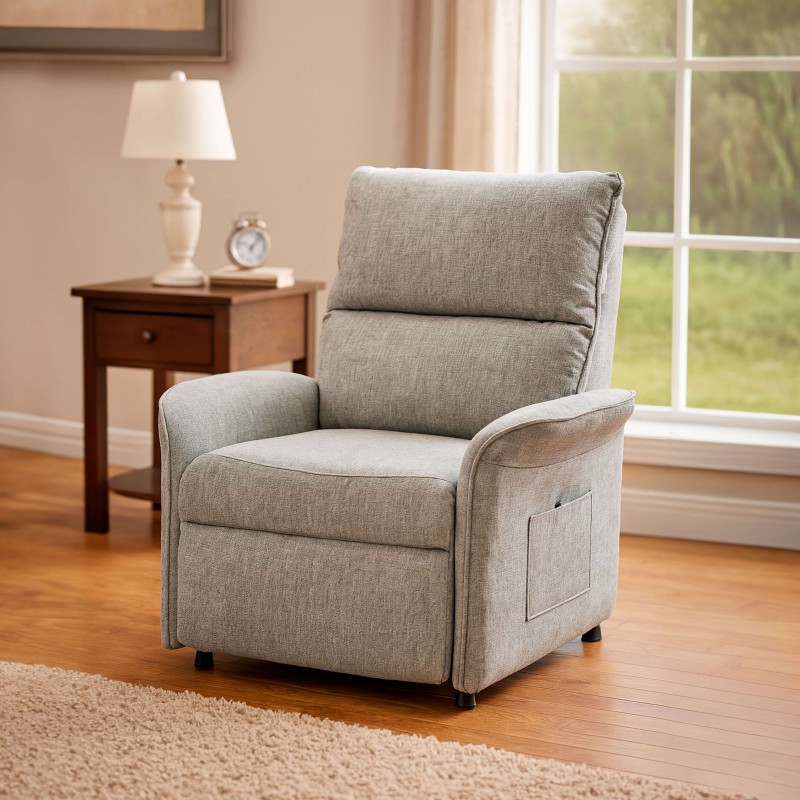 Sillón reclinable tapizado en gris claro con respaldo acolchado y bolsillo lateral en ambiente de sala