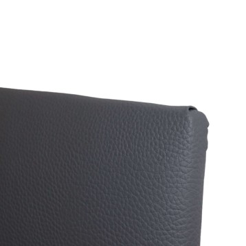 Detalle de cabecero tapizado en cuero gris oscuro con textura piel grabada