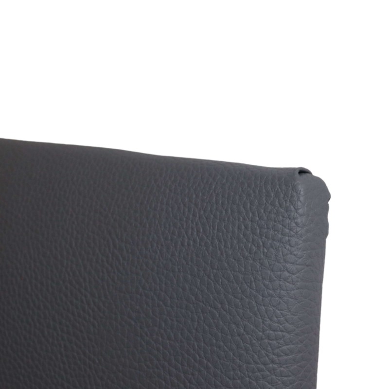 Detalle de cabecero tapizado en cuero gris oscuro con textura piel grabada