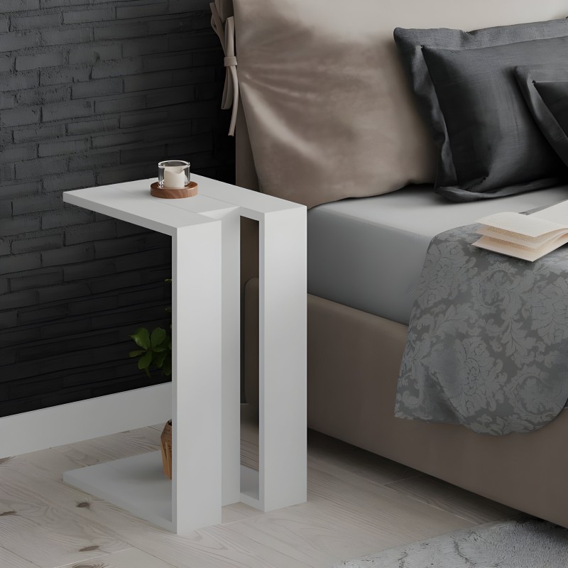 Mesa auxiliar blanca con hueco abierto junto a sofá gris en ambiente dormitorio