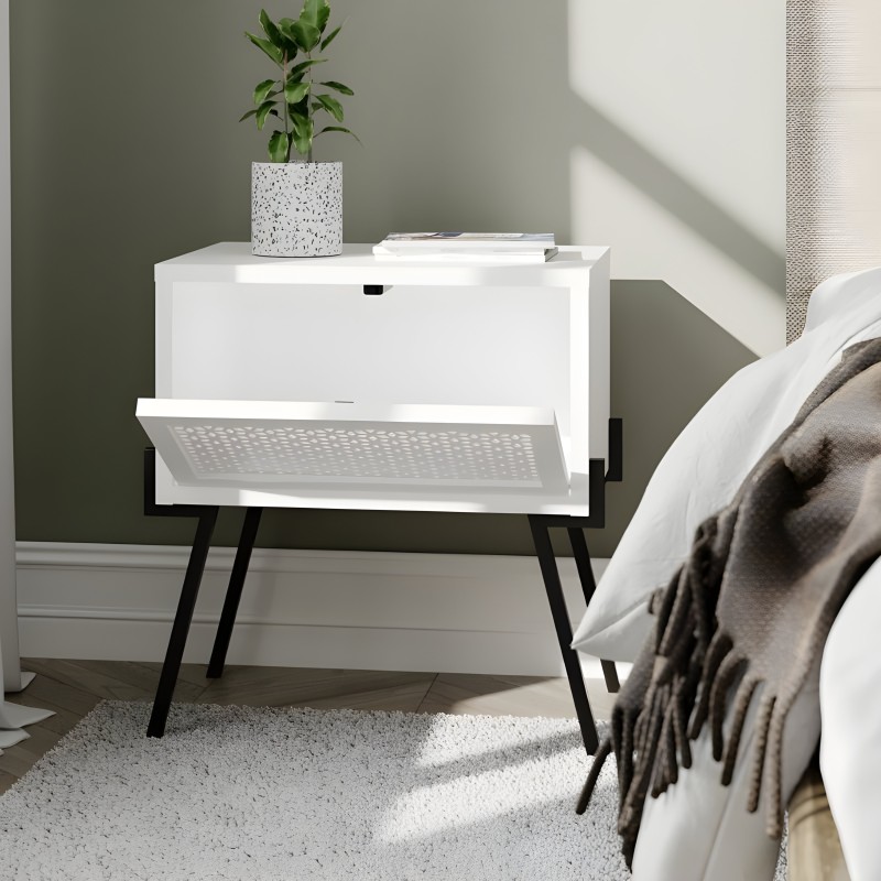 Mesita de noche blanca con cajón y patas negras en dormitorio junto a cama