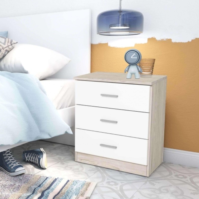 Mesita de noche con tres cajones blancos y estructura en tonos claros junto a cama en ambiente de dormitorio