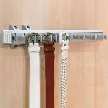 Perchero de pared gris con raíl y ganchos decorativos sosteniendo cinturones blancos y marrones