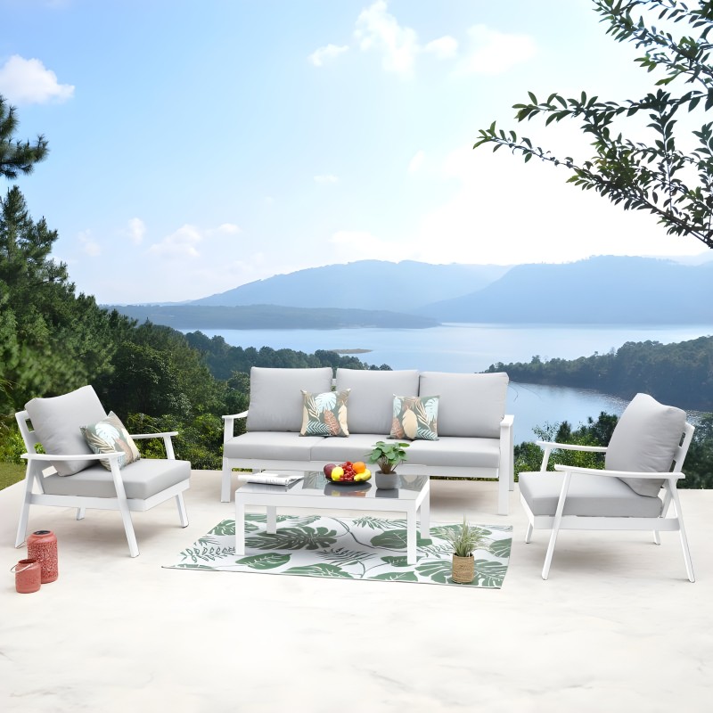 Conjunto de sofá y sillones de aluminio blanco con cojines grises en terraza con vistas al lago
