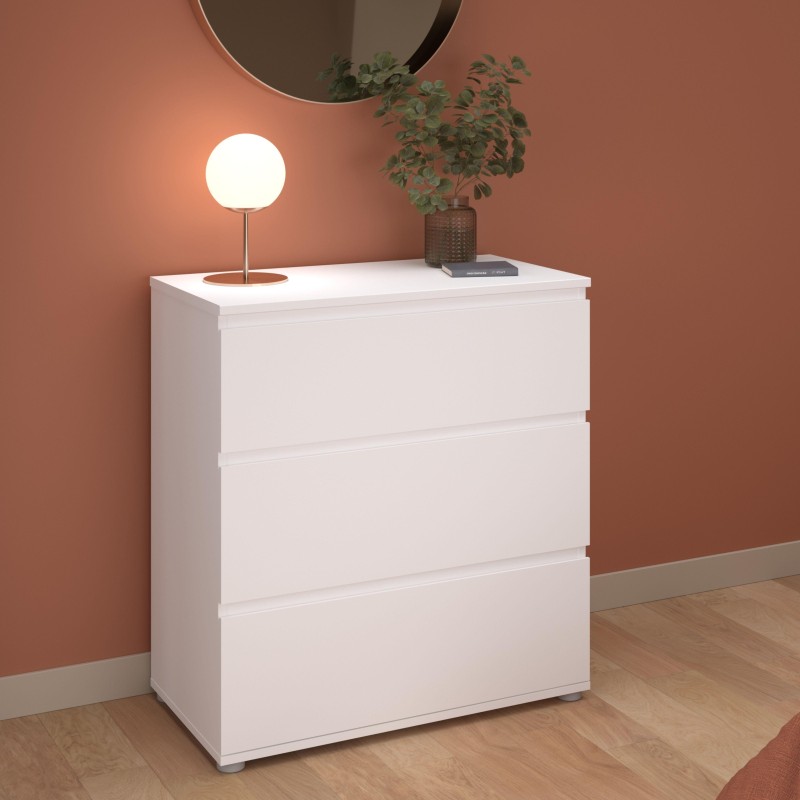 Cómoda blanca de tres cajones en ambiente decorado con espejo redondo y lámpara de mesa