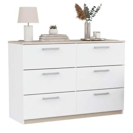 Cómoda blanca con seis cajones y encimera roble decorada con lámpara y plantas en ambiente