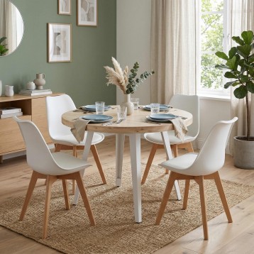 Comedor redondo con tablero de madera natural y base blanca acompañado de cuatro sillas blancas con patas de madera en ambiente