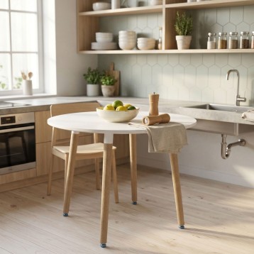 Mesa redonda blanca con patas de madera natural en cocina moderna y luminosa