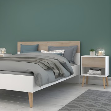 Cama con cabecero de madera clara y estructura blanca con patas de madera y ropa de cama gris en dormitorio