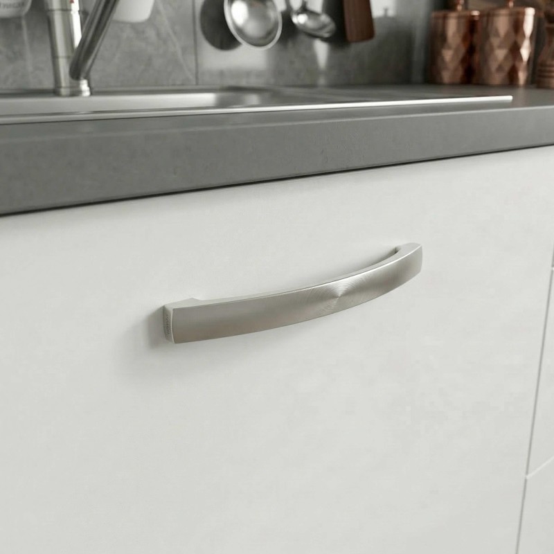 Mueble de cocina blanco con tirador curvo plateado y encimera gris oscuro en detalle