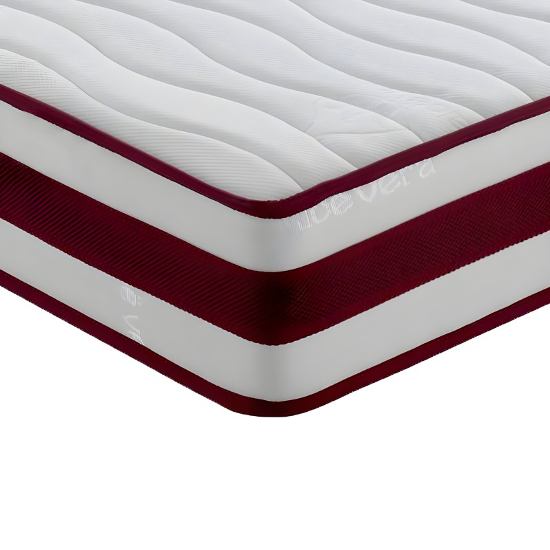 Detalle de colchón con capas visibles blanco y burdeos con superficie acolchada y bordes ribeteados