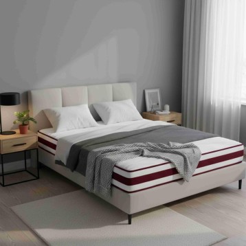 Cama tapizada con cabecero acolchado color crema y colchón con franjas blancas y burdeos en ambiente de dormitorio