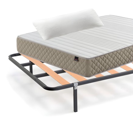 Colchón acolchado beige con almohada blanca sobre base negra con láminas de madera y metal