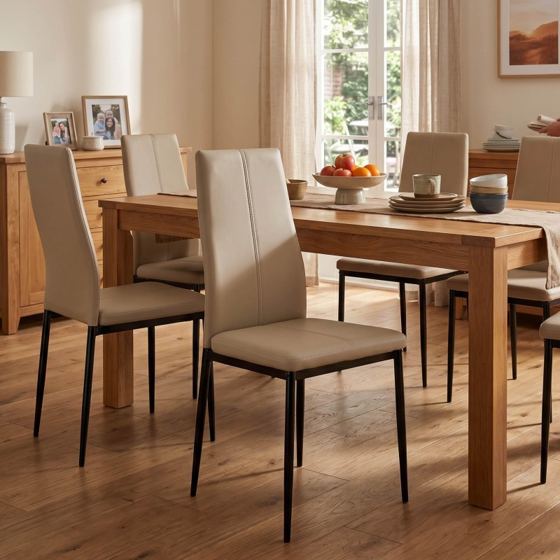 Comedor con mesa de madera clara y sillas tapizadas en beige con patas negras en ambiente luminoso