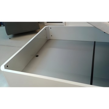 Cama blanca con cajón de almacenamiento abierto y división interior negra en detalle de estructura