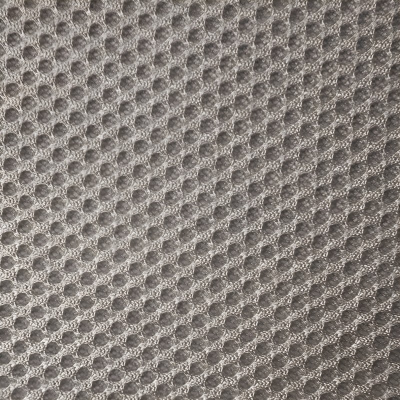 Detalle de tapicería gris claro con textura acolchada y patrón de puntos en relieve