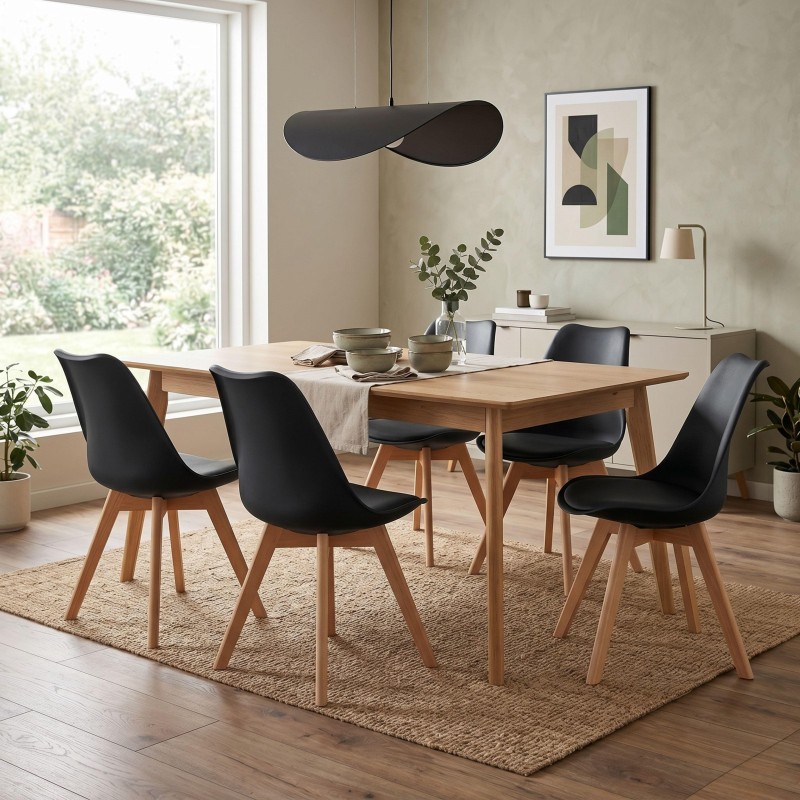 Comedor con mesa de madera natural y sillas negras de asiento acolchado y patas de madera en ambiente luminoso