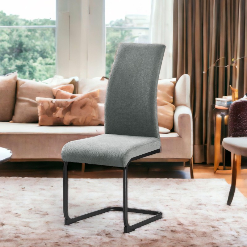 Silla tapizada en gris con respaldo alto y estructura metálica negra en ambiente de sala junto a sofá beige