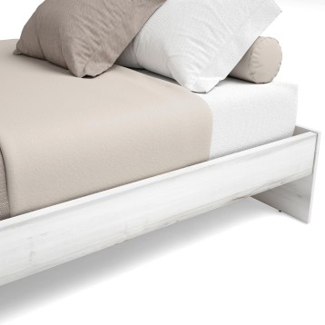 Cama blanca con colchón beige y almohadas en tonos neutros de tela textil vista frontal